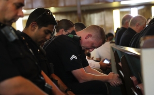 Policiais orando em uma vigília de oração em Dallas, no Texas. (Foto: Spencer Platt/Getty Images)