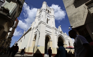As pessoas andam perto da Igreja de Nossa Virgem da Caridade, em Havana, Cuba. (Foto: Reuters/Desmond Boylan)