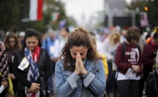 Mulher ora em ação ao ar livre. (Foto: Reuters/Brian Snyder)