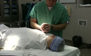 Imagem ilustrativa. Médico em oração com paciente antes de cirurgia. (Foto: John Neff/Shutterstock)