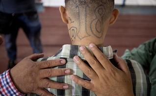 José Rolando Arévalo, 24 anos, ex-membro de uma gangue, recebe oração de pastores. (Foto: Alicia Vera)