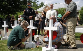 Mulher escreve homenagem para Michelle Langer, uma das vítimas do tiroteio em um prédio municipal de Virginia Beach. (Foto: AP Photo/Patrick Semansky)