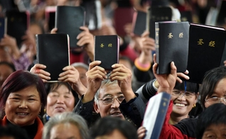 Cristãos Chineses mostram suas Bíblias em culto. (Foto: Bible Society - Australia)