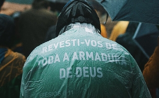 Em Porto Alegre, homem usa capa com versículo bíblico durante ato. (Foto: Matheus Bazzo)