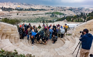 Grupo de turistas tira foto no Monte das Oliveiras, com a cidade velha de Jerusalém em segundo plano. (Foto: Shutterstock)