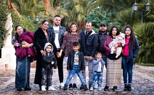 Belle Barbu, no meio da blusa colorida, se reúne com sua família na Itália 25 anos após ser levada. (Foto: Operation Underground Railroad)