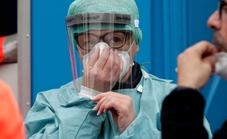 Profissional de saúde se prepara enquanto recebe recomendações para atendimento de infectados na Itália. (Foto: AP Photo)