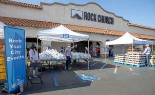 Voluntários entregam mantimentos a famílias necessitadas em frente à Rock Church. (Foto: Rock Church/Christy)