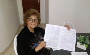 Maria Petrina exibe um dos cadernos com cópias da Bíblia. (Foto: Reprodução)