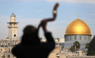 Homem toca shofar com o Monte do Templo ao fundo, em Jerusalém. (Foto: Reuters/Ammar Awad)