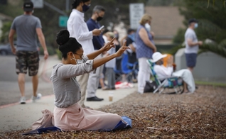 Mulher ora em frente ao colégio Mt. Carmel durante o evento “We Pray San Diego”, na Califórnia. (Foto: Nancee E. Lewis/San Diego Union Tribune)