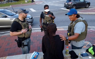 Investigadores conversam com menina resgatada de traficantes, após ação dos 'US Marshals', nos EUA. (Foto: CBN News)