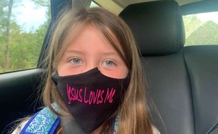 Lydia Booth foi proibida de usar sua máscara com a inscrição "Jesus Loves Me" ("Jesus me Ama") e agora sua família está processando a escola onde ela cursa a 3ª série. (Foto: Alliance Defending Freedom)