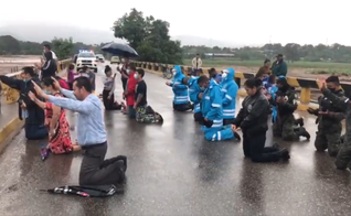 Policiais oram com cristãos em uma ponte sobre o rio Ulúa. (Foto: Policía Nacional de Honduras)