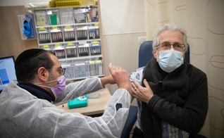 Homem recebe vacina da Covid-19 em posto de vacinação de Jerusalém, em 30 de dezembro de 2020. (Foto: Noam Revkin Fenton/Flash90)