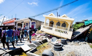 Pessoas do lado de uma casa destruída após um terremoto de magnitude 7,2 em Les Cayes, Haiti. (Foto: Ralph Tedy/Reuters)