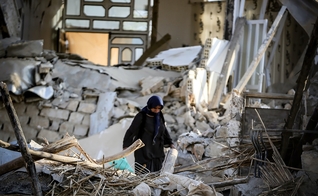 Mulher no meio dos escombros de um terremoto. (Foto: Ilustração/Unsplash/Moein Rezaalizade)