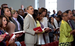 Na imagem, Barack Obama aparece junto à sua família, participando de um culto em meio a outros fiéis.