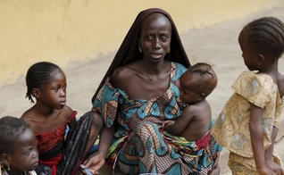 Mulher resgatada do Boko Haram alimenta um de seus filhos no campo de refugiados, na Nigéria. (Foto: Reuters/Afolabi Sotunde)
