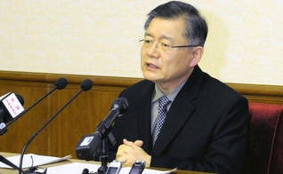 Vestido com um terno azul escuro, Hyeon Soo Lim falou a um pequeno público. (Foto: Reuters)