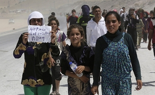 Mulheres e homens da etnia Yazidi em fuga da opressão imposta pelo Estado Islâmico na cidade de Sinjar. (Foto: Reuters / YOUSSEF BOUDLA)
