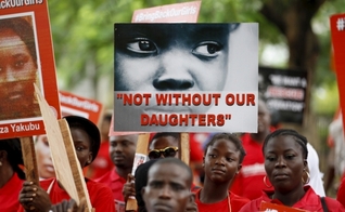 Familiares e amigos participam de manifestação, clamando pelo resgate das meninas sequestradas pelo Boko Haram em 2014, segurando placas como esta, que diz "Não sem nossas filhas"e com o lema "Tragam nossas garotas de volta" (Foto: Reuters)