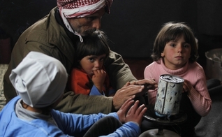 Refugiado alimenta sua família em campo, na Jordânia. (Foto: Reuters/Muhammad Hamed)