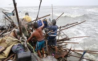 Uma família que vive na baía de Manila tenta achar pertences que possam ser recuperados, após a sua casa ter sido destruída por fortes ventos trazidos pelo tufão Koppu neste domingo, 18/10. (Foto: Romeo Ranoco/Reuters)