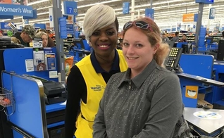 A funcionária Sharnique Dasant ao lado da cliente Ashley Jordan, em frente ao caixa do Walmart. (Foto: Reprodução/Facebook)