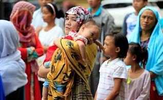 Mãe segura seu filho em meio ao caos instalado nas Filipinas, após cerco de terroristas. (Foto: Reuters)