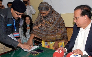 Asia Bibi coloca sua digital em um documento de recurso contra a condenação de sentença de morte. (Foto: AFP)