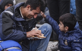 Garoto vê seu pai chorando durante um protesto de migrantes iraquianos do Paquistão e Marrocos. (Foto: CNS/Georgi Licovski/EPA)