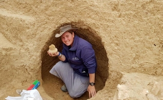 Arqueólogo segura objeto de 2.000 anos descoberto na escavação. (Foto: Divulgação/Autoridade de Antiguidades de Israel)