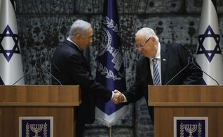 Benjamin Netanyahu aperta a mão do presidente de Israel, Reuven Rivlin. (Foto: Menahem Kahana/AFP)