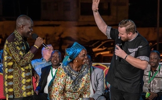 Mulher que se rastejava fica de pé e começa a andar durante Conferência Fire, no Togo. (Foto: Reprodução/O. Volyk)
