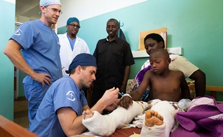 Médicos cuidam de Amié, de 9 anos, depois de uma cirurgia extensa em suas pernas. (Foto: David K. Morrison/Samaritan's Purse)