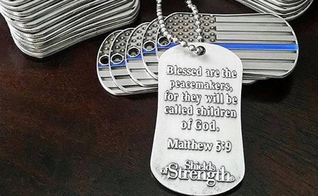 Dog tag com a inscrição de Mateus 5:9, que diz "Bem-aventurados os pacificadores, porque serão chamados filhos de Deus". (Foto: Reprodução/Shields of Strength)