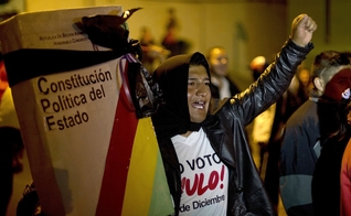 Manifestante com uma réplica gigante da constituição da Bolívia, embrulhada com uma fita preta de luto, em La Paz, Bolívia, em 2017. (Foto: Juan Karita/AP)