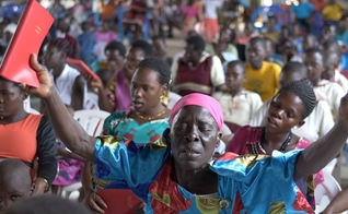 Mulher segura o Novo Testamento escrito em Lugwere pela primeira vez. (Foto: Reprodução/Wycliffe Bible Translators)