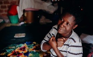 Africana surda evangelizada por linguagem de sinais. (Foto: Reprodução/Deaf Bible Society)