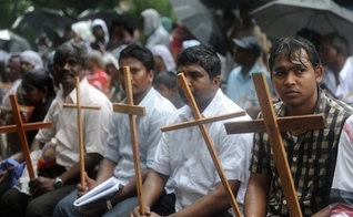 Cristãos seguram cruzes como símbolo de sua fé. (Foto: Reprodução/AFP)