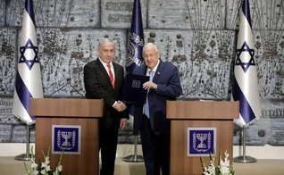 O presidente de Israel, Reuven Rivlin, dá as mãos ao primeiro-ministro Benjamin Netanyahu, como o escolhido para permanecer no cargo e formar governo no país. (Foto: Sebastian Scheiner/AP)