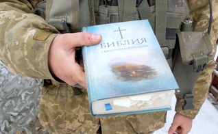 Policial segura uma Bíblia. (Foto: Reprodução/Mission Eurasia)