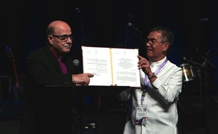 Munir Salim Kakish, presidente do Conselho de Igrejas Evangélicas Locais na Terra Santa [à esquerda], e o bispo Efraim Tendero, secretário geral da Aliança Evangélica Mundial [à direita] mostram documento da Autoridade Palestina. (Foto: Reprodução/WEA)