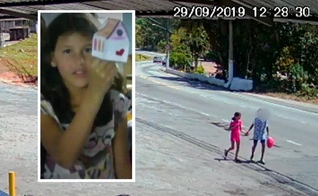 A menina Raíssa de mãos dadas com adolescente, em Perus. (Foto: Reprodução/TV Globo)