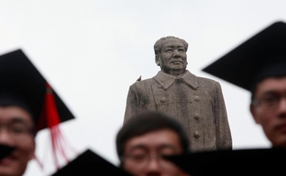 Graduados posam para foto em frente à estátua do líder chinês Mao Tsé Tung após sua cerimônia de formatura na Universidade de Fudan, em Xangai. (Foto: Aly Song/Reuters)