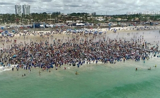 Igreja leva milhares de pessoas para serem batizadas na praia de Jaguaribe, em Salvador. (Foto: Reprodução/G1)
