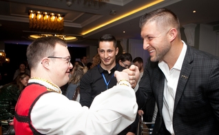 Tim Tebow cumprimenta um convidado na "Night to Shine", na Albânia. (Foto: Reprodução / Fundação Tim Tebow)