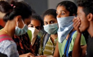 Estudantes usando máscaras aguardam para comprar bilhetes em estação de trem em Kochi, na Índia, na terça-feira (10). (Foto: Reuters/Sivaram V)