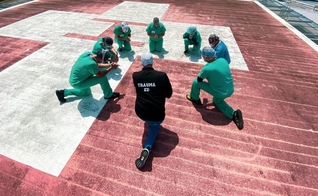 Funcionários do Jackson South Medical Center, na Flórida, oram no heliporto do hospital. (Foto: Jackson Health System)